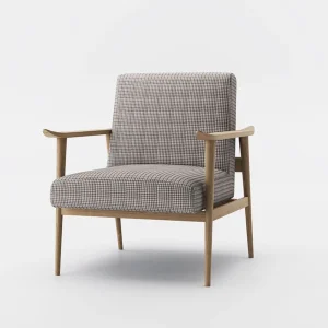 Mid-century modern armchair with checkered brown and beige upholstery, angled wooden legs, and natural wood armrests, placed on a patterned rug over hardwood flooring.