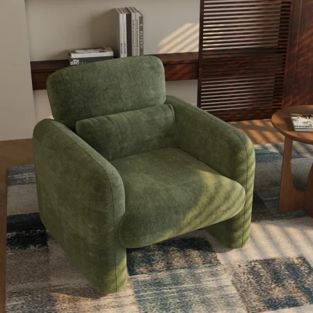 Green chenille accent chair with rounded edges, deep seat cushion, and matching lumbar pillow in a minimalist interior setting.