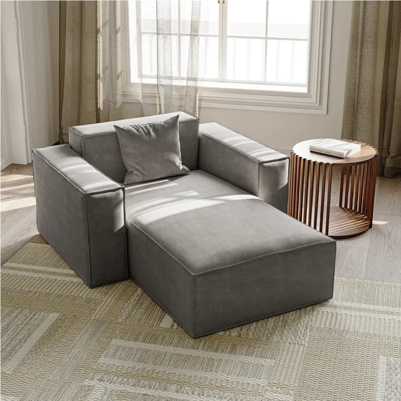 Dark gray fabric chaise lounge chair with squared armrests, low profile, and matching throw pillow in a minimalist design.