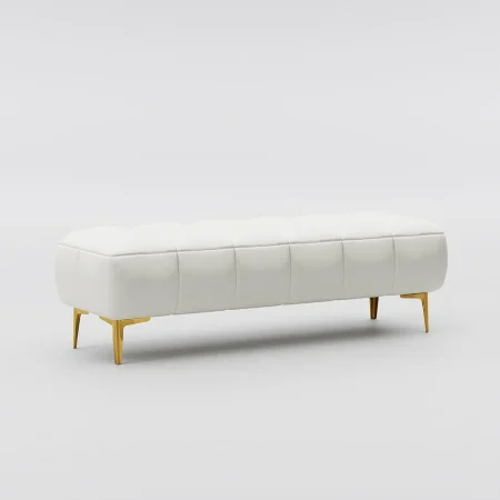 White tufted bench with gold legs on a plush carpet, placed near a large window with horizontal blinds and white slippers in front.