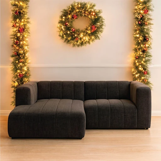 A living room scene with a comfortable couch and a decorative Christmas wreath displayed on the wall above it.