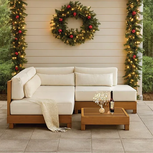 A white couch accompanied by a wreath on the wall, emphasizing a chic outdoor furniture arrangement