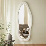 Irregular full-length mirror with wavy flannel frame, plush cushioning, and sculptural silhouette