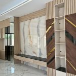 “Marble + walnut herringbone + brass diagonals = feature wall perfection.”
3.peak 2025 vibes.” A luxurious modern TV feature wall clad in large-format white marble with dramatic gold and gray veining, framed by light-oak vertical fluted panels and dark-walnut herringbone sections accented with diagonal brushed-brass inlays. A floating black marble console sits below the TV area, flanked by asymmetrical open shelving and mirrored storage cabinets.