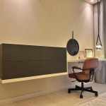 A sleek workspace composition blending wall-mounted storage, curated accents, and airy modern design. Floating desk and cabinet with framed art, pendant light, office chair, and minimalist decor.